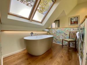 a large bath tub in a bathroom with skylights at Knockendarroch Hotel in Pitlochry +76 photos