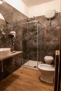 een badkamer met een douche, een toilet en een wastafel bij Santé in San Nicandro Garganico