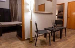 een kamer met een tafel en stoelen en een bed bij Santé in San Nicandro Garganico