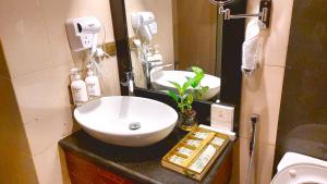 a bathroom with a white sink and a mirror at Golden Dune Hotel Almalaz in Riyadh