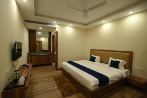 a bedroom with a large bed and a television at Namastey Puri in Puri