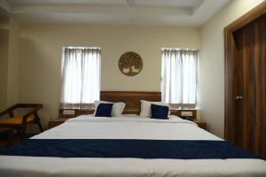 a bedroom with a large bed and two windows at Namastey Puri in Puri