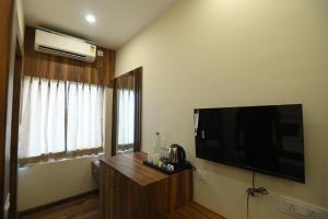 a living room with a large flat screen tv on the wall at Namastey Puri in Puri