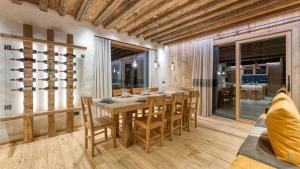 Un comedor con mesa y sillas de madera. en Akchalet Akaroa, en Livigno