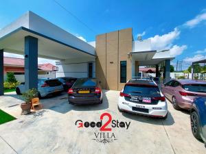 un grupo de autos estacionados en un estacionamiento en Good2Stay Villa en Melaka