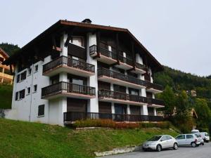 ル・グラン・ボルナンにあるAppartement Le Grand-Bornand, 3 pièces, 7 personnes - FR-1-241-122の車が目の前に停まった大きな建物