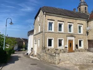an old stone house with a brown door on a street at Deluxe Double Rooms Helfant Luxembourg 