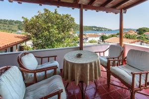 a patio with chairs and a table on a balcony at Chrissomalli Sofia Studios in Skiathos