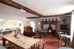 a living room with tables and chairs and a fireplace at Black Lion Hotel in Little Walsingham