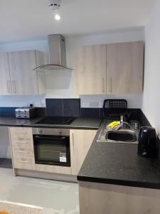a kitchen with a sink and a stove top oven at windies apartment 2 in Bridlington