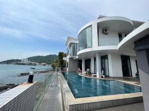 a house with a swimming pool next to the water at Nancy Tran Grand Strip Vung Tau Villa 8 in Vung Tau