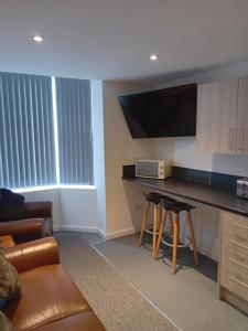 a living room with a couch and a table with a microwave at windies apartment 2 in Bridlington