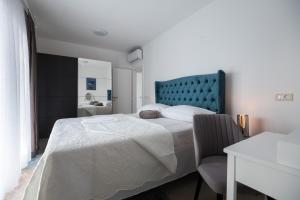 a bedroom with a large bed and a chair at Villa Marta in Sukošan +29 photos