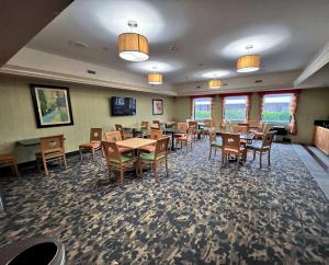 a dining room with tables and chairs and windows at Best Western Plus Glen Allen Inn in Richmond