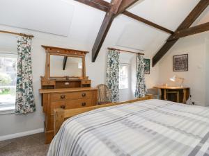 a bedroom with a bed and a dresser and a mirror at Oxford House in Minehead