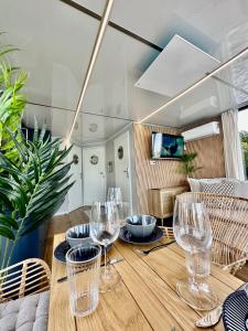 a dining room table with wine glasses on it at Domki na wodzie - Resort 36 Houseboats in Giżycko