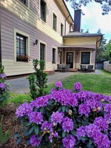 uma casa com flores roxas no quintal em Guest House & Villa Astoma em Palanga