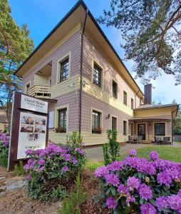 uma casa velha com flores em frente em Guest House & Villa Astoma em Palanga