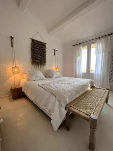 ein weißes Schlafzimmer mit einem großen Bett und einem Fenster in der Unterkunft Magnifique villa avec piscine, splendide vue mer. in Porto-Vecchio