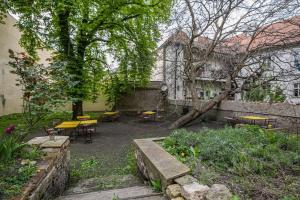 een binnenplaats met tafels en stoelen en een boom bij Lovely Historical home in Mala Strana - N1st in Praag