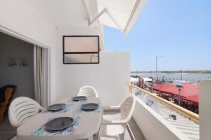 comedor con mesa y sillas en el balcón en Cabanas Mar 96 en Cabanas de Tavira