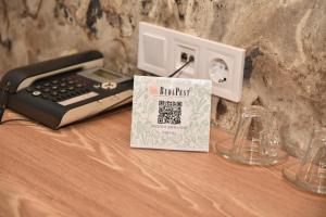 a desk with a phone and a clock and a book at Budapest Hotel in Sofia