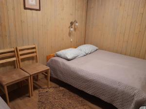 a small bedroom with a bed and a chair at Käbi Holiday Homes in Ainja