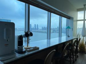 a room with a large window with a view of the city at Gwanganli The Club Hotel in Busan