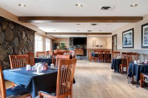 un restaurante con mesas y sillas y una pared de piedra en Days Inn by Wyndham Victoria Uptown, en Victoria