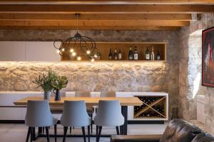 a dining room with a table and some wine bottles at Villa MaR-sea view,private pool in Orasac