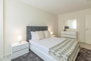 una camera da letto bianca con un letto grande e due comodini di Apartamento Bela Vista - Minho's Guest a Esposende Altre 35 foto