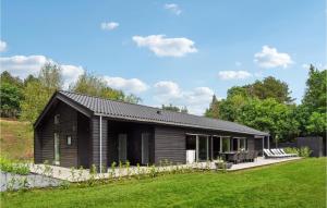 uma pequena casa preta com um jardim de relva em 7 Bedroom Lovely Home In Ebeltoft em Ebeltoft