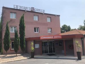 a pink building with a sign that reads the hamnsics hotel at Hôtel Originals City Mas de Grille in Saint-Jean-de-Védas
