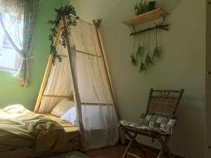 um quarto com uma cama de dossel e uma cadeira em Whispering Pines Dalat (Thông Thì Thầm ĐL) em Da Lat