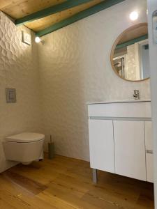 a bathroom with a toilet and a mirror at Glass Boutique - Rooms & Suites in Marinha Grande
