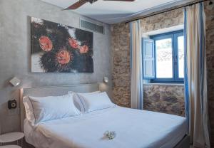 Masseria Della Volpe في Casale Modica: غرفة نوم بسرير ابيض مع نافذة