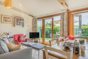a living room with a table and chairs and a tv at Chestnut Lodge in East Dean