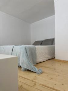 un letto con coperta su un pavimento in legno di Glass Boutique - Rooms & Suites a Marinha Grande