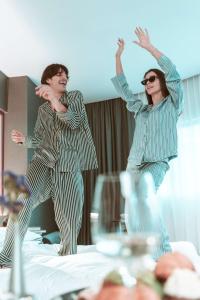 two people jumping on a bed in a room at Andaz Mexico City Condesa - A Concept by Hyatt in Mexico City