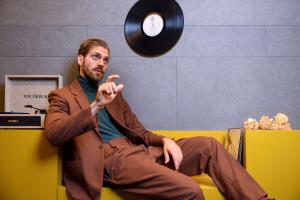 a man sitting on a couch throwing a record at Andaz Mexico City Condesa - A Concept by Hyatt in Mexico City