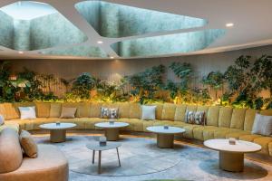 um átrio com sofás, mesas e plantas em Andaz Mexico City Condesa - A Concept by Hyatt em Cidade do México