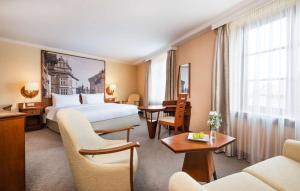 um quarto de hotel com uma cama, uma mesa e cadeiras em Lindner Hotel Prague Castle, part of JdV by Hyatt em Praga