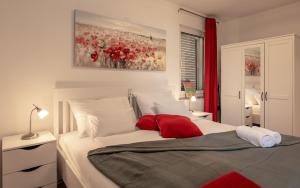 una camera da letto con un letto grande con cuscini rossi di Pool apartment Adriana a Pag Altre 49 foto