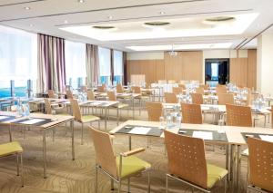 a large room with tables and chairs andwindows at Lindner Hotel Vienna Am Belvedere, part of JdV by Hyatt in Vienna