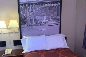 a picture of a bridge is hanging above a bed at Super 8 by Wyndham Youngstown Girard in Youngstown