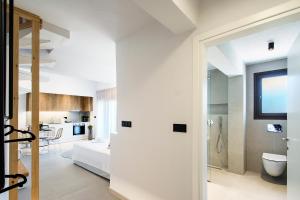 Habitación blanca con baño y dormitorio en Chrissomalli Sofia Studios, en Skiathos