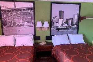 a hotel room with two beds and two pictures on the wall at Super 8 by Wyndham Youngstown Girard in Youngstown