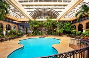 a large swimming pool in a building with a ceiling at Courtland Grand Hotel, Trademark Collection by Wyndham in Atlanta