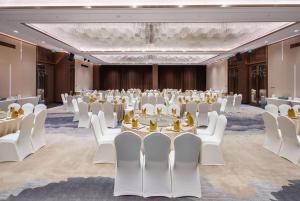 een feestzaal met witte tafels en witte stoelen bij Wyndham Garden Shenzhen Longhua in Shenzhen +69 foto's