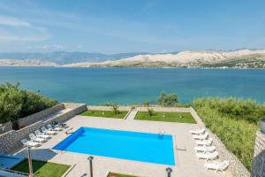 a swimming pool with a view of a lake at Pool apartment Adriana in Pag